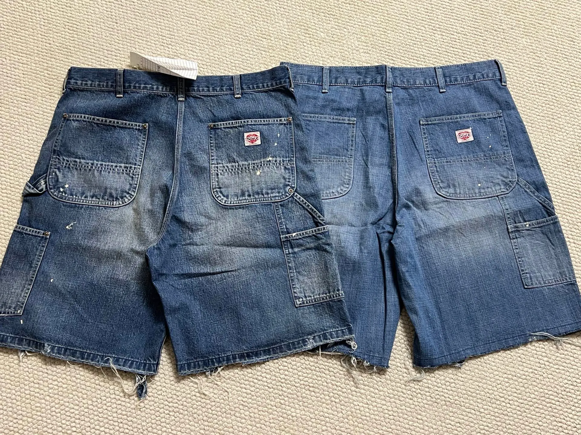 SAINT Mxxxxxx DOUBLE KNEE SHORTS/BLU Knee patches splashed with ink and water-splashed denim shorts. Denim blue S-XL. Custom-woven and dyed denim fabric with clear texture. Heavy-wash water-fading treatment to create local mottled fading/hole effects. Artificial distressing to simulate natural wearing marks. VINTAGE sense. Original consistent damage treatment. Hand-splashed ink and paint. Original consistent wash mark/pocket mark. Double knee patch. Rivet reinforcement. Improve functionality while enhancing design